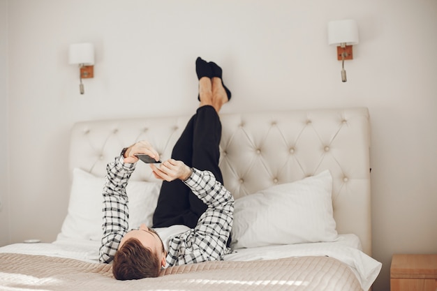 Retrato de hombre relajado en casa con smartphone