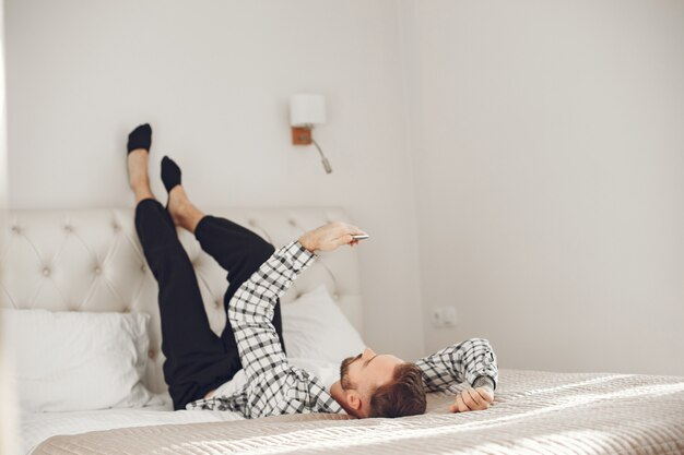 Retrato de hombre relajado en casa con smartphone