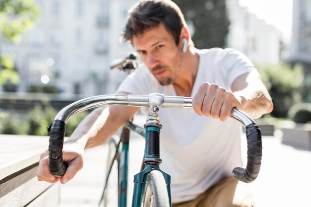 Retrato de hombre reparando su bicicleta al aire libre