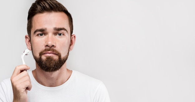 Retrato de hombre con un rodillo facial con espacio de copia