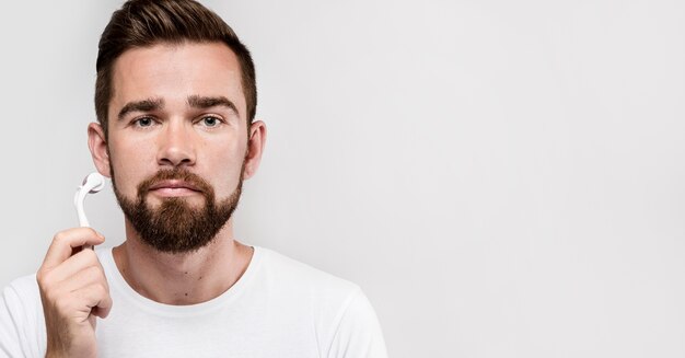 Retrato de hombre con un rodillo facial con espacio de copia