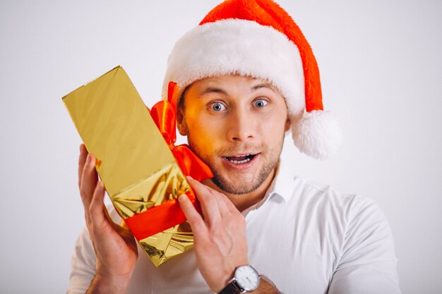 Retrato de hombre en santa sombrero sosteniendo navidad oro presente caja