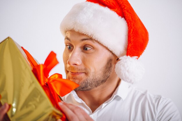 Retrato de hombre en santa sombrero sosteniendo navidad oro presente caja