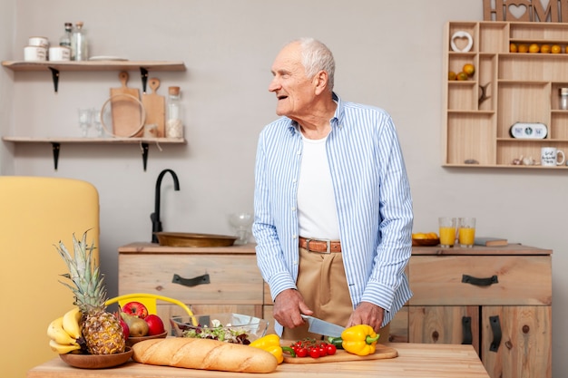 Retrato de hombre senior cortar verduras