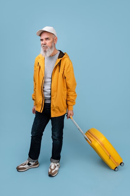Retrato de hombre senior de tiro completo con equipaje