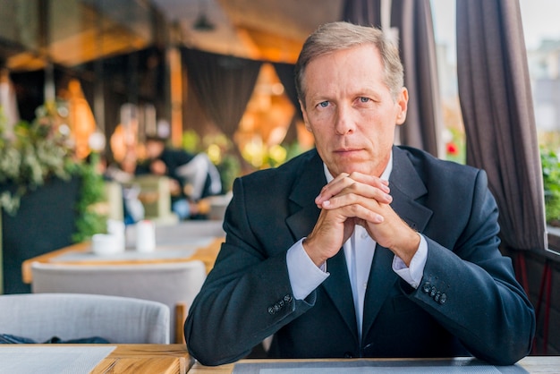 Retrato de un hombre serio sentado en el restaurante