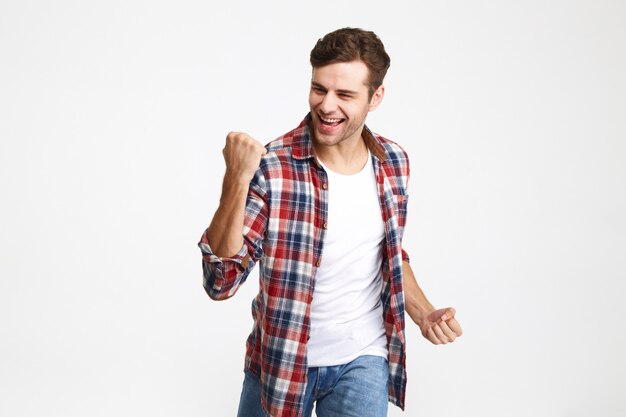 Retrato de un hombre sonriente emocionado celebrando el éxito