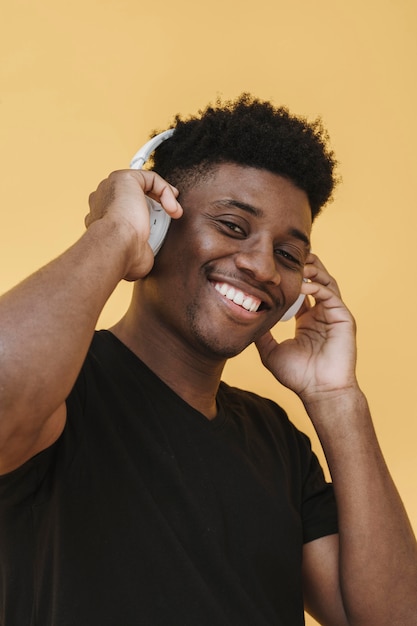 Retrato de hombre sonriente escuchando música con auriculares