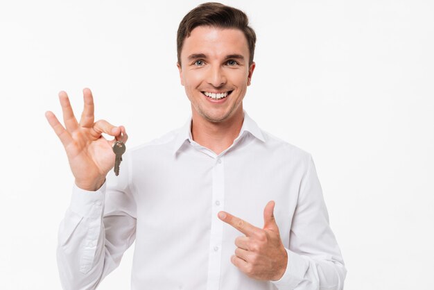 Retrato de un hombre sonriente feliz en camisa con llaves