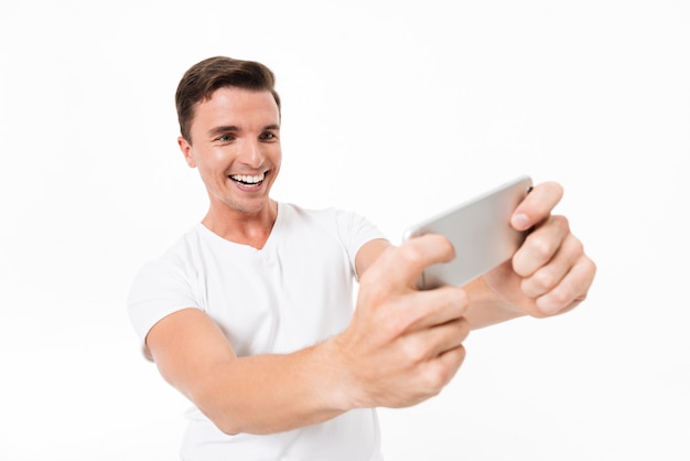 Retrato de un hombre sonriente feliz en camiseta blanca