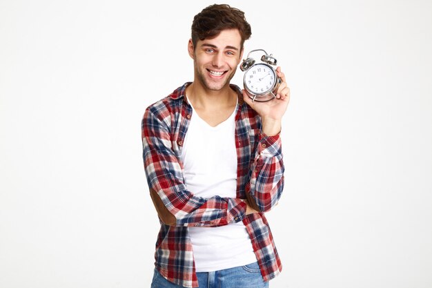 Retrato de un hombre sonriente feliz mostrando despertador