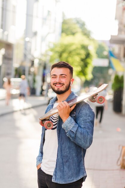 Retrato de un hombre sonriente con patín