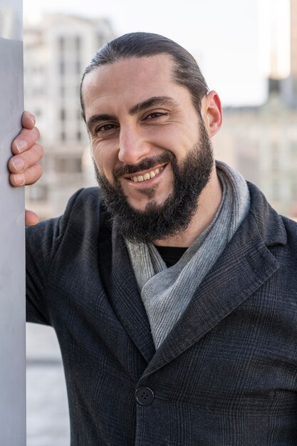 Retrato de hombre sonriente posando al aire libre