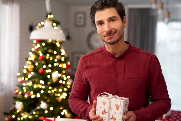 Retrato de hombre sonriente con regalo de Navidad