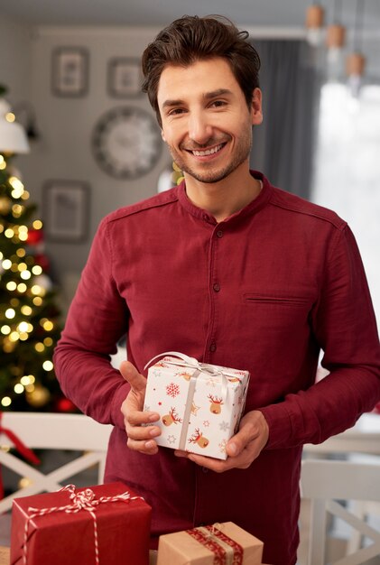 Retrato de hombre sonriente con regalo de Navidad