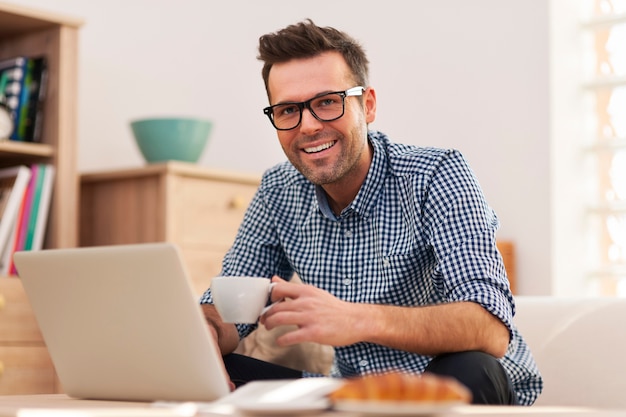 Retrato de hombre sonriente trabajando en casa