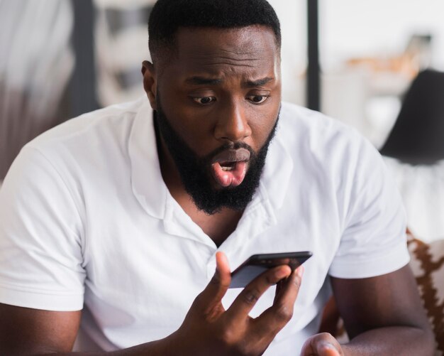 Retrato de hombre sorprendido después de ver su teléfono