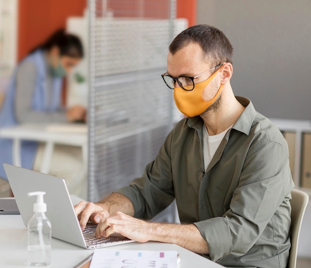 Retrato de hombre vestido con mascarilla en el trabajo