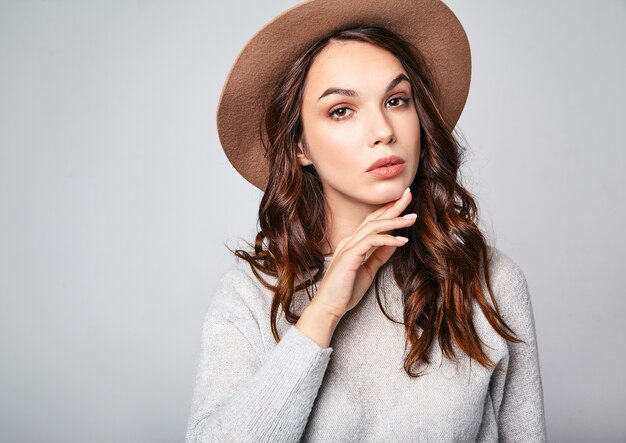 Retrato horizontal de elegante modelo femenino atractivo viste ropa de verano y sombrero marrón con maquillaje natural