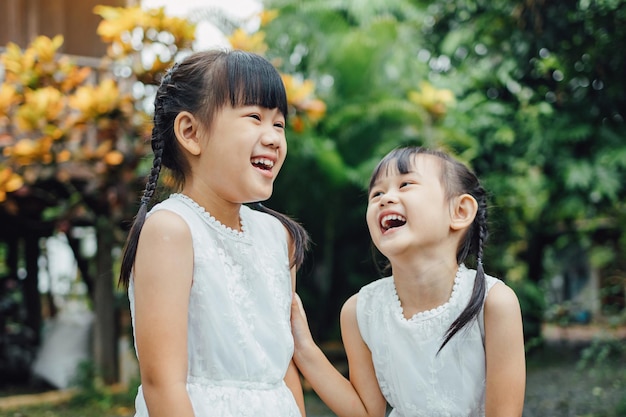 Retrato infantil de una expresión facial emocional de sonrisa y risa de niños hermanos asiáticos