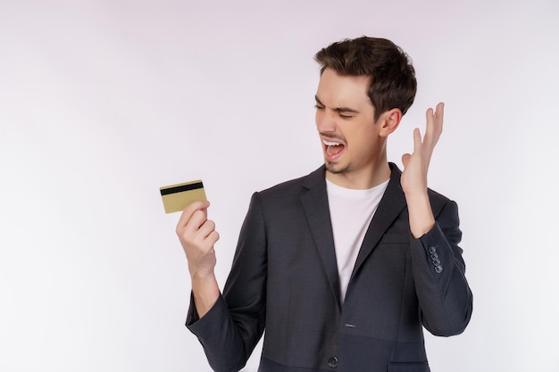 Retrato de infeliz empresario mostrando tarjeta de crédito aislado sobre fondo blanco.