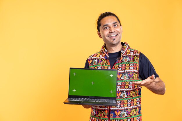 Retrato de un influyente sonriendo mientras presenta una computadora portátil de pantalla verde