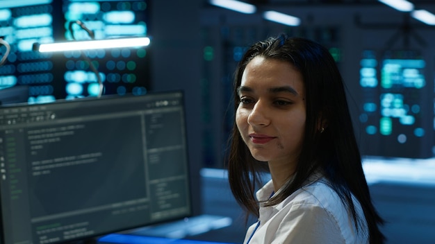 Retrato de un ingeniero alegre en un centro de datos instalando software en una computadora