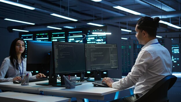 Retrato de un ingeniero alegre en un centro de datos instalando software en una computadora
