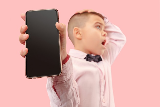 Retrato interior de atractivo joven sosteniendo smartphone en blanco