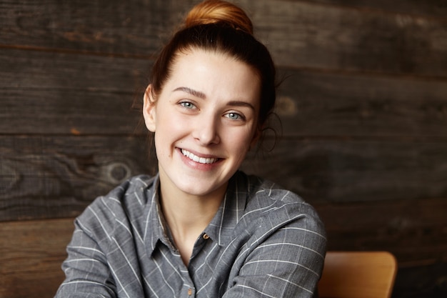 Foto gratuita retrato de interior de hermosa joven estudiante de raza caucásica con piel sana perfecta