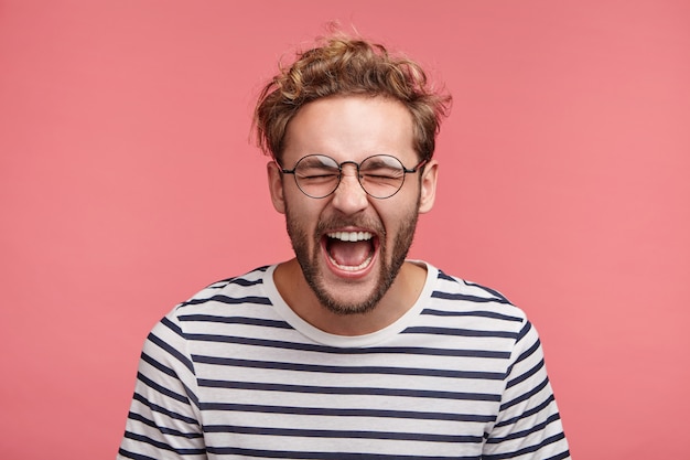 Retrato interior de joven barbudo con peinado de moda