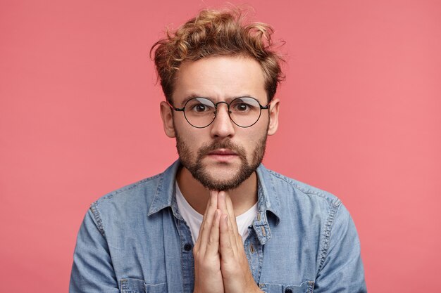 Retrato interior de joven barbudo con peinado de moda