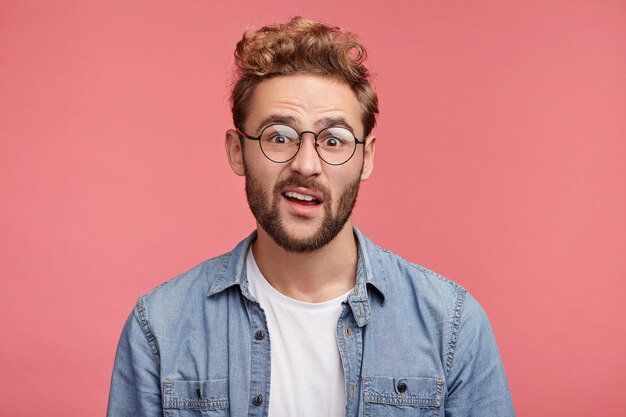 Retrato interior de joven barbudo con peinado de moda