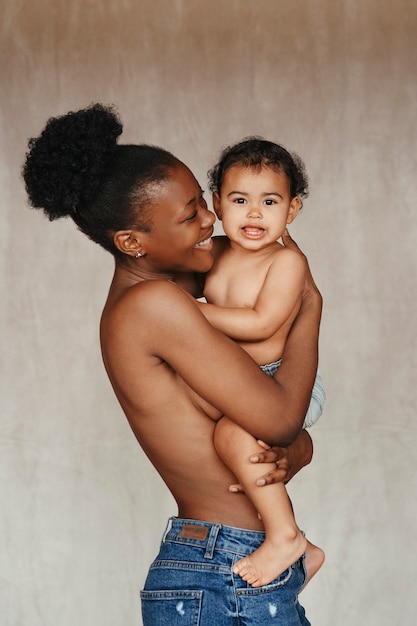 Foto gratuita retrato íntimo de una hermosa madre sosteniendo a su bebé