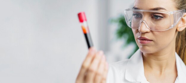 Retrato de investigadora en el laboratorio con tubo de ensayo y espacio de copia