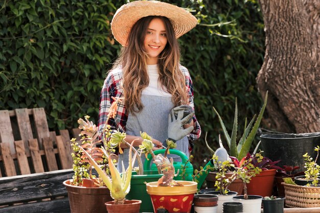 Foto gratuita retrato del jardinero de sexo femenino sonriente que se coloca en jardín