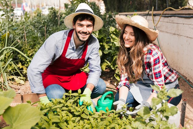 Retrato de un jardinero de sexo masculino y de sexo femenino que trabaja en el jardín