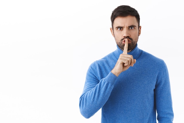 Retrato de un jefe estricto de aspecto serio callando a la persona que habla durante la reunión calla con la cara enojada regañando a la gente presione el dedo a los labios cállate por favor fondo blanco Copiar espacio