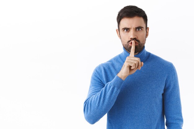 Retrato de un jefe estricto de aspecto serio callando a la persona que habla durante la reunión calla con la cara enojada regañando a la gente presione el dedo a los labios cállate por favor fondo blanco Copiar espacio