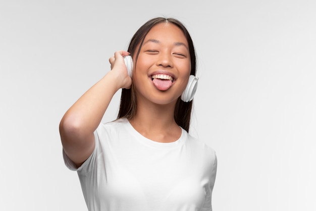 Retrato de joven adolescente con auriculares escuchando música