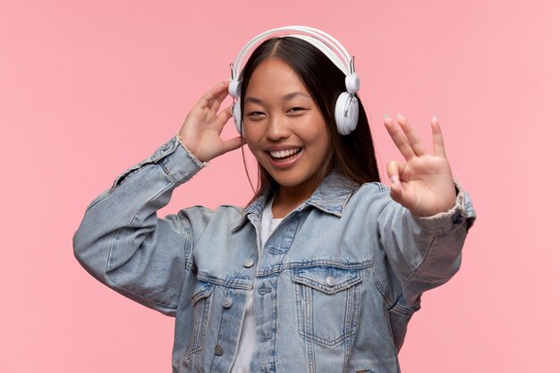 Retrato de joven adolescente con auriculares mostrando signo bien