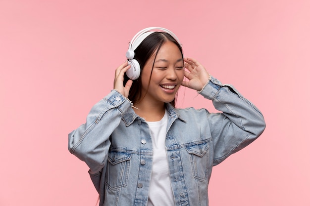 Retrato de joven adolescente escuchando música con sus auriculares