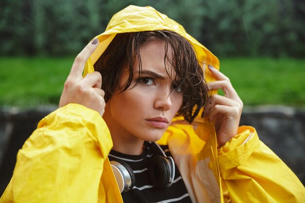 Retrato de una joven adolescente molesta vistiendo impermeable