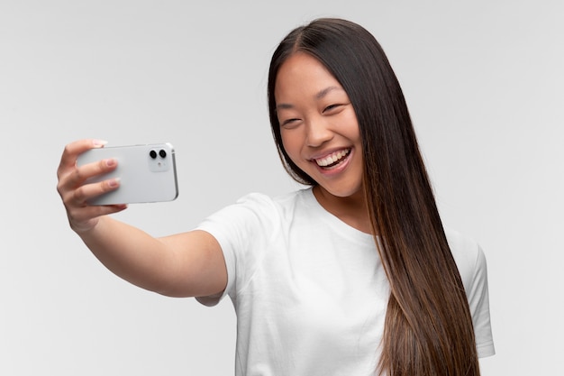 Retrato de joven adolescente tomando selfie con smartphone