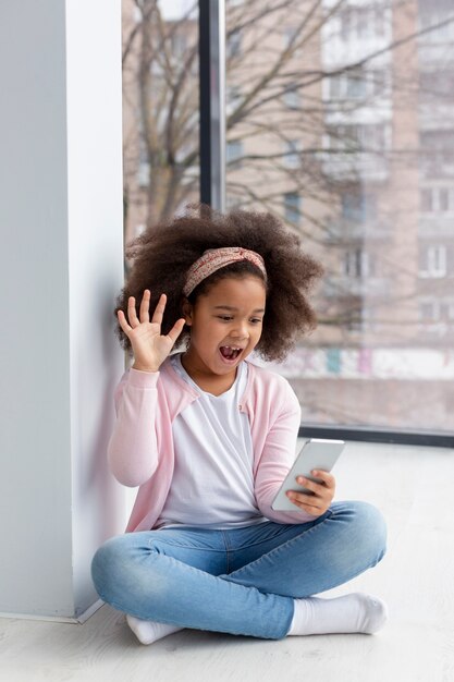 Retrato de joven adorable jugando con su teléfono