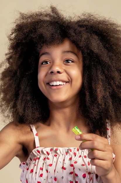 Retrato de joven adorable posando mientras juega con pompas de jabón