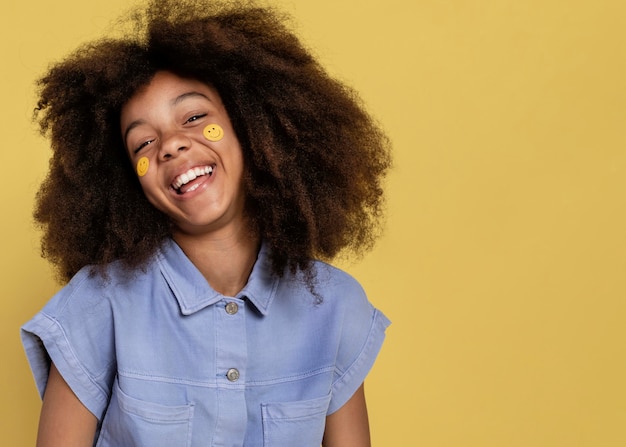 Retrato de joven adorable posando con pegatinas emoji en su rostro