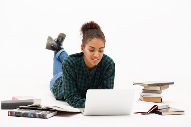 Retrato de una joven africana con una computadora portátil en blanco