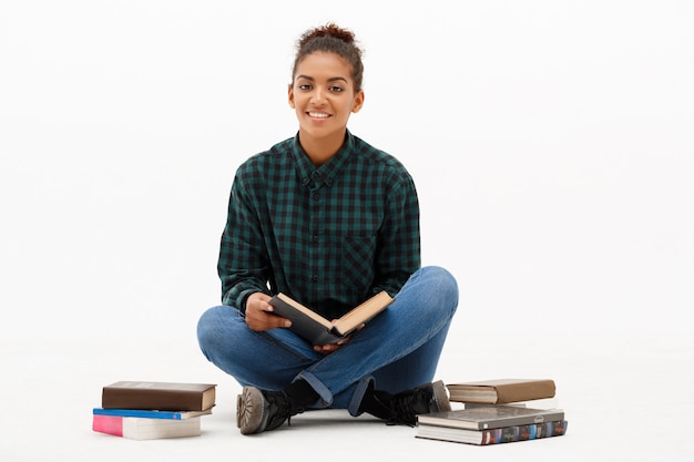 Retrato de joven africana con libros en blanco.