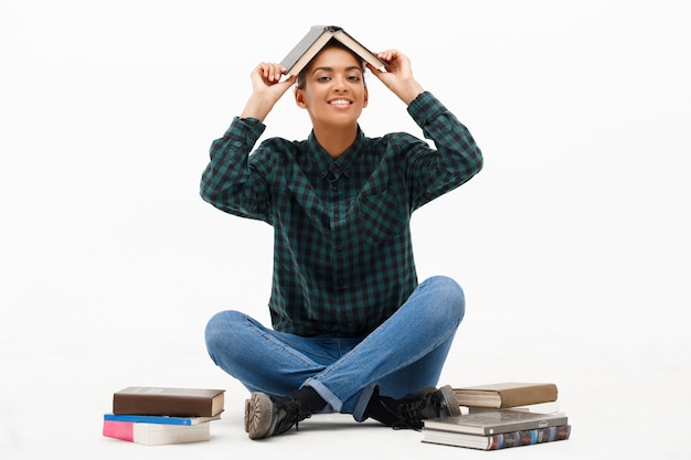 Foto gratuita retrato de joven africana con libros en blanco.